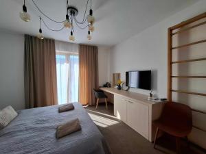 a bedroom with a bed and a desk with a television at VIGEO lounge b&b coffee in Bojnice
