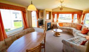 a living room with a couch and a table at WW252 Parkdean Camber Sands in Camber