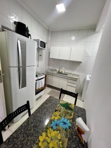 una cocina con una mesa con flores. en Apê na PG only 150 Metros da Praia, en Praia Grande