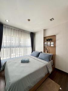 a bedroom with a large bed with blue pillows at The City Hatyai D20 in Sathani Khlong Rian