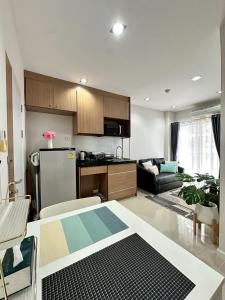 a kitchen and living room with a refrigerator and a couch at The City Hatyai D20 in Sathani Khlong Rian