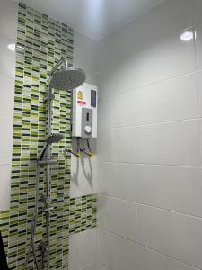 a shower in a bathroom with green and white tiles at The City Hatyai D20 in Sathani Khlong Rian