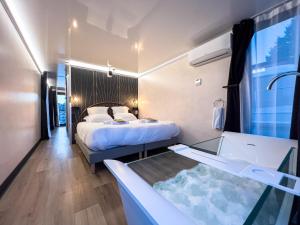 a hotel room with a bed and a bath tub at L'Escale Royale Saverne - Rhin - Strasbourg in Saverne