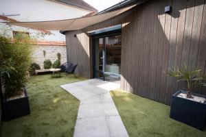 an internal garden with a patio and grass at Les Jardins Secrets - Gare & Centre by Apparts Spa Dijon in Dijon