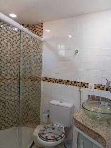 a bathroom with a toilet and a glass shower at Chalé em Búzios 100m da Praia de Tucuns in Búzios