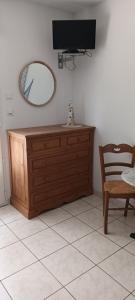Un espejo y una cómoda en una habitación con una silla. en La picarde, en Le Crotoy