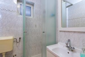 un baño con ducha y lavabo en Apartments Kurdija, en Punat 15 fotos más