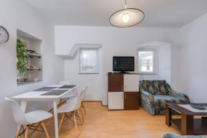 una sala de estar con una mesa y una silla en Apartments Kurdija, en Punat