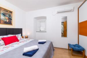Un dormitorio con una cama grande y una silla. en Apartments Kurdija, en Punat