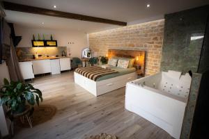 a bedroom with a bed and a tub in a room at Les Jardins Secrets - Gare & Centre by Apparts Spa Dijon in Dijon