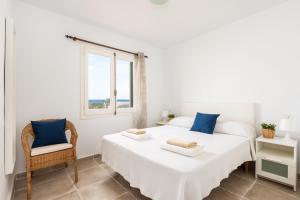 a white bedroom with two beds and a window at Apartamento Els Pins by Escapehome in Punta Grossa +9 photos