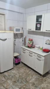 a kitchen with white cabinets and a white refrigerator at Pousada Andrey in Niterói