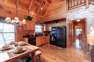 a kitchen with wooden cabinets and a black refrigerator at Cozy Secluded Cabin Firepit Hot Tub in Pigeon Forge