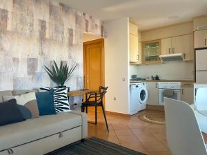 a living room with a couch and a kitchen at El Nido del Sol in La Oliva