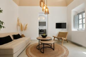 a living room with a couch and a table at Arxegono Cave Houses Santorini in Pyrgos