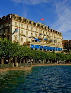 un bâtiment à côté d'une masse d'eau dans l'établissement Hotel Splendide Royal, à Lugano