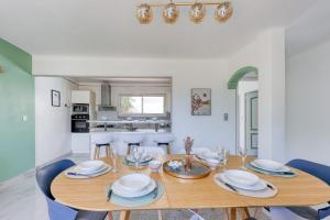 Un comedor con mesa y sillas de madera. en Villa Helvétie - Welkeys, en Toulon