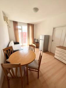 a kitchen with a table and chairs and a refrigerator at Sunny day 5 in Tŭnkovo