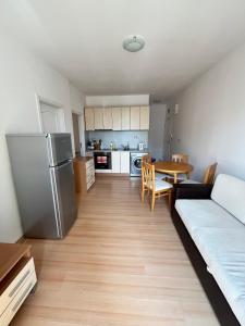 a kitchen and living room with a couch and a table at Sunny day 5 in Tŭnkovo