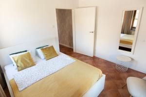 Un dormitorio con una cama con almohadas amarillas y un espejo. en Apartament BIANCO CREMA przy Jasnej Górze, en Częstochowa