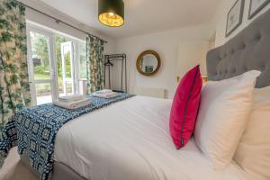 een slaapkamer met een groot wit bed met rode kussens bij Cae-Calch in Morfa Nefyn