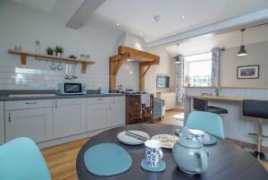 una cucina e una sala da pranzo con tavolo e sedie di Gegin-Faeldre a Llanbedr