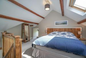 una camera da letto con letto blu in mansarda di Gegin-Faeldre a Llanbedr