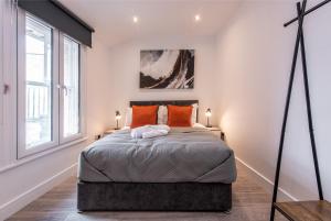a bedroom with a large bed with orange pillows at 2-Bed Apartment, Basingstoke - Great Location in Basingstoke