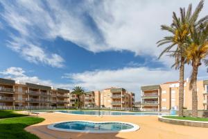 a resort with a swimming pool and palm trees at Apartamento Al Lado De La Playa in Pulpí