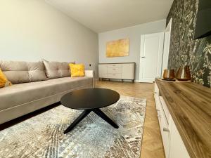 a living room with a couch and a table at Naujai įrengti apartamentai Morkus Šiauliai in Šiauliai