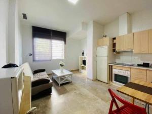 Una cocina y una sala de estar con un sofá y una mesa. en Apart 4- Trip - Benalmadena, en Benalmádena