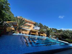a swimming pool in front of a hotel at Hotel George in Ureki