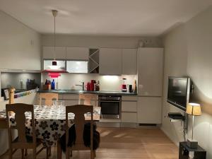 a kitchen with a table with chairs and a television at Leisure apartment at Sinnes in Haugen