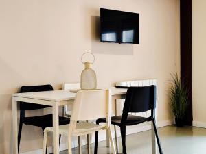 a white dining room table with chairs and a lamp at Apartamentos Loft Urdaibai Bermeo in Bermeo