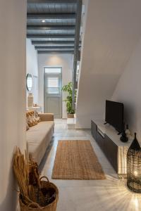 a living room with a couch and a tv at Caper-2 Bedroom traditional home with amazing view in Naousa