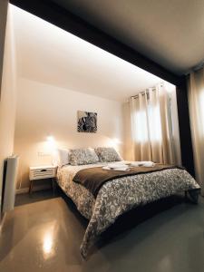 a bedroom with a large bed with a large window at Apartamentos Loft Urdaibai Bermeo in Bermeo