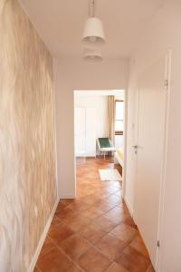 Un pasillo con paredes blancas y suelo de baldosas. en Apartament BIANCO CREMA przy Jasnej Górze, en Częstochowa
