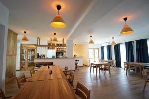 a restaurant with wooden tables and chairs and windows at Doi Căpitani II in Crisan