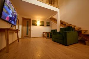 a living room with a tv and a green couch at Doi Căpitani II in Crisan