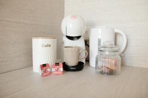 a coffee maker and cups on a counter at Studio meublé Le Refuge doré avec Netflix in Homécourt