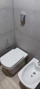 a bathroom with a white toilet and a sink at Hermosa Casa Con pileta y quincho in Villa Nueva