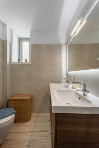 a bathroom with a sink and a toilet and a mirror at Caper-2 Bedroom traditional home with amazing view in Naousa +41 photos