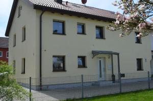 a white house with black windows and a fence at Ferienwohnung Gabler in Landsberg am Lech