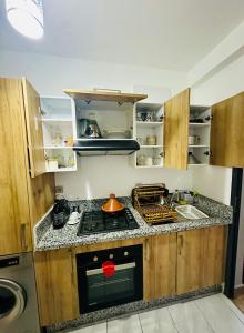 a small kitchen with a stove and a sink at Appartement a zenata ain-harrouda casablanca in Mohammedia