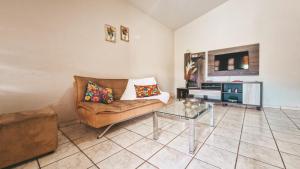 a living room with a couch and a glass table at Pousada Casa da Chirlei in Capitólio