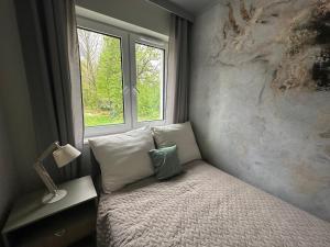 Un dormitorio pequeño con una cama con ventana. en Enduro Spot - Apartament pod Kozią Górą, en Bielsko-Biala