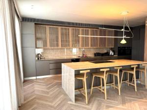 a kitchen with a large wooden island with bar stools at VILLA Leonard וילה לאונרד אילת in Eilat