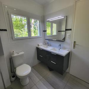 een badkamer met een toilet, een wastafel en een spiegel bij Détente à la mer Blanche in Fouesnant +49 foto's