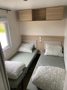 a small room with two beds and a window at chalet 6 personen HZ23 in Lauwersoog