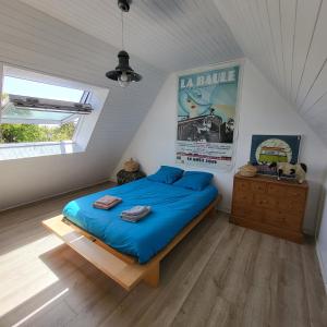 een slaapkamer met een blauw bed op een zolder bij Détente à la mer Blanche in Fouesnant